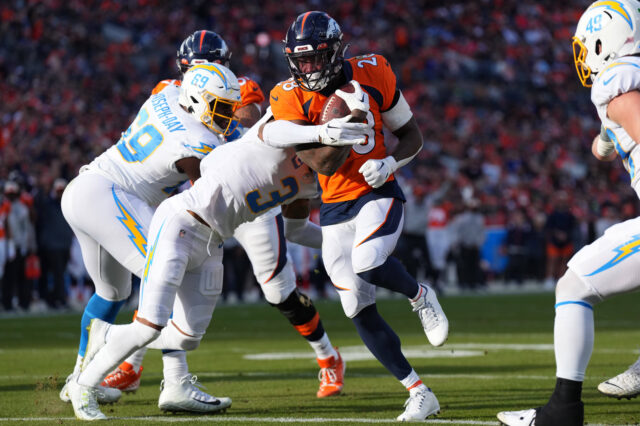 Denver Broncos running back Latavius Murray (28) scores a touchdown past Los Angeles Chargers safety Derwin James Jr. (3) in the first quarter at Empower Field at Mile High.