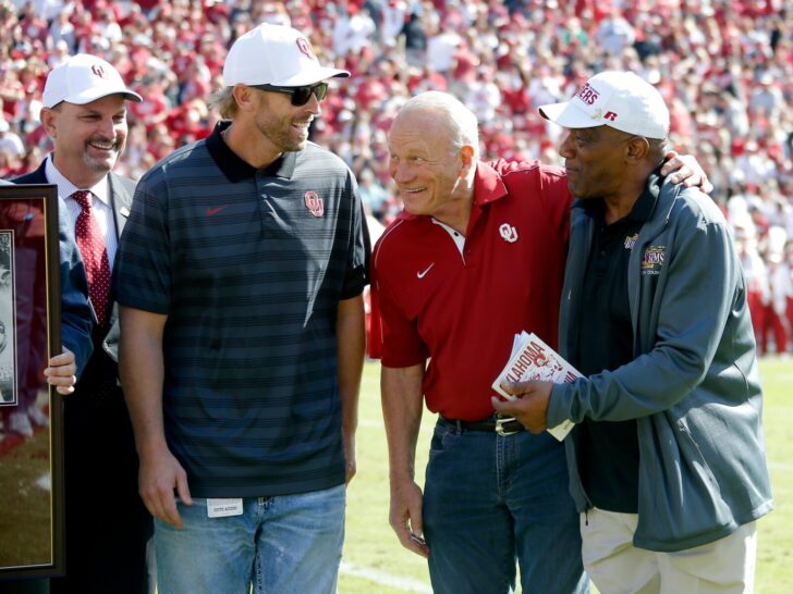 Oklahoma athletic director Joe Castiglione, fomer Heisman Trophy winners Jason White, second from left, and Billy Sims, at right, with former Oklahoma coach Barry Switzer gather during halftime of a college football game between the University of Oklahoma Sooners (OU) and the West Virginia Mountaineers at Gaylord Family-Oklahoma Memorial Stadium in Norman, Okla, Saturday, Oct. 19, 2019. Oklahoma won 52-14.