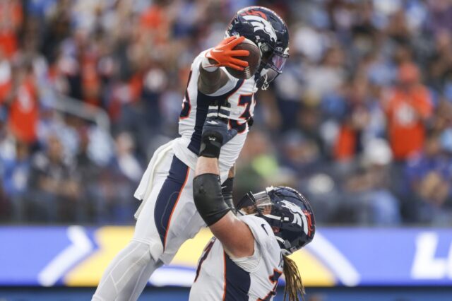 Quinn Meinerz lifts Javonte Williams in a touchdown celebration.