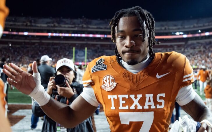 Jahdae Barron gives a teammate a high five. A photographer follows him.
