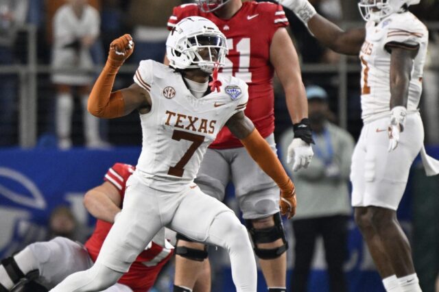 Jahdae Barron celebrates on the field with another Texas teammate.
